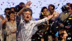 Top opposition presidential candidate Mauricio Macri dances and sings after speaking to supporters in Buenos Aires, Argentina, Sunday, Oct. 25, 2015.