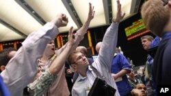 Traders work in the crude oil and natural gas options pit on the floor of the New York Mercantile Exchange in New York, (file photo April 25, 2011)