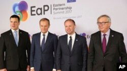 FILE - Malta's Prime Minister Joseph Muscat, second right, is welcomed by, from left, Estonian Prime Minister Juri Ratas, European Council President Donald Tusk and European Commission President Jean-Claude Juncker during arrivals for an Eastern Partnership Summit in Brussels, Friday, Nov. 24, 2017. 