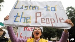 A protester shouts slogans demanding tax reform outside the Ministry of Finance in Taipei, Taiwan, Dec. 27, 2018. A large group of activists has launched anti-government protests to demand tax reform, inspired by the demonstrations in Paris that began last month.