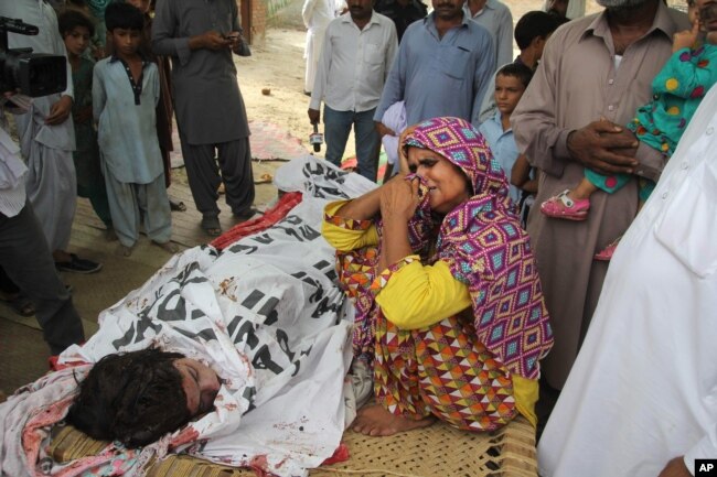 FILE - The mother of slain Pakistani social media star Qandeel Baloch mourns beside her dead body in Shah Sadderuddin, Pakistan, July 18, 2016. Baloch was killed by her brother for what he called “intolerable” behavior.