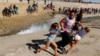 Maria Lila Meza Castro, center, a 39-year-old migrant woman from Honduras, runs away from tear gas with her 5-year-old twin daughters Saira Nalleli Mejia Meza, left, and Cheili Nalleli Mejia Meza near the border between the U.S. and Mexico, in Tijuana, Mexico, Nov. 25, 2018. 