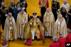 Raja Inggris Charles III menerima Mahkota St Edward saat upacara penobatannya di Westminster Abbey, di London, Sabtu, 6 Mei 2023. (Andrew Matthews via AP)