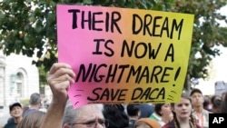 FILE - Judy Weatherly, a supporter of the Deferred Action for Childhood Arrivals (DACA), holds up a sign during a protest outside of the Federal Building in San Francisco, Sept. 5, 2017.