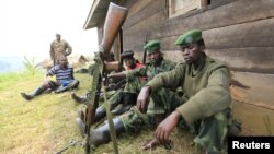 Tentara pemberontak Kongo, M23 beristirahat dalam posisi siaga di Karambi, provinsi Kivu bagian utara, dekat perbatasan Uganda (12/7).