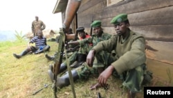 M23 rebel fighters rest at their defense position in Karambi, eastern Democratic Republic of Congo (DRC) in north Kivu province, near the border with Uganda, July 12, 2012. 