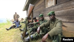 M23 rebel fighters rest at their defense position in Karambi, eastern Democratic Republic of Congo (DRC) in north Kivu province, near the border with Uganda, July 12, 2012. 