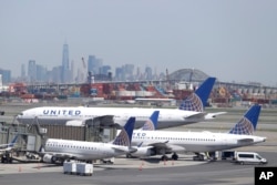 The New York City skyline is seen in the distance as United Airlines jets sit at gates at Newark Liberty International Airport, May 2, 2018, in Newark, New Jersey.