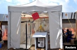 A doctor cares for a patient inside an isolate cube at The Alliance for International Medical Action treatment center in Beni, North Kivu province of the Democratic Republic of Congo Sept. 6, 2018.