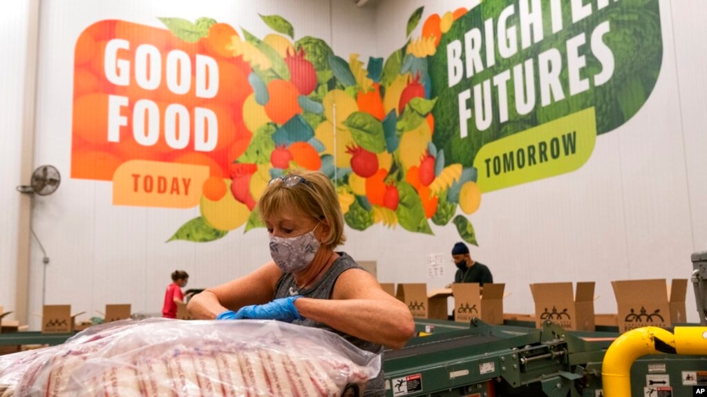 Volunteers pack boxes of food for distribution, at The Capital Area Food Bank, in Washington, Oct. 5, 2021. 