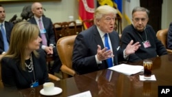 President Donald Trump, flanked by GM CEO Mary Barra and Fiat Chrysler Automobiles CEO Sergio Marchionne, gestures while speaking at the start of a meeting with automobile leaders in the Roosevelt Room of the White House in Washington, Jan. 24, 2017. 
