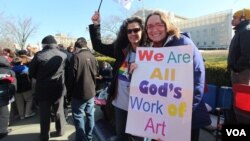 Гей-пара держит плакат с надписью: «Мы все – искусство божье».