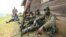 M23 rebel fighters rest at their defense position in Karambi, eastern Democratic Republic of Congo (DRC) in north Kivu province, near the border with Uganda, July 12, 2012. 