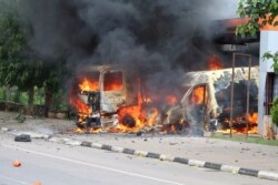 FILE - An ambulance and a fire engine set on fire by a Shi'ite group are seen at the Federal Secretariat in Abuja, July 22, 2019.