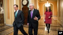 Senate Majority Leader Mitch McConnell, center, walks with Sen. Pat Toomey to the chamber for the vote to impose more stringent sanctions on North Korea, Feb 10, 2016.