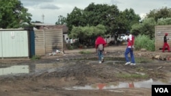 Residents of Mbare township - navigate through raw sewerage one of the causes of typhoid, a waterborne disease which Zimbabwean authorities are battling to end since the beginning of the rainy season. (Photo: S. Mhofu / VOA)