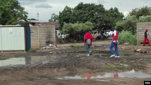 Residents of Mbare township - navigate through raw sewerage one of the causes of typhoid, a waterborne disease which Zimbabwean authorities are battling to end since the beginning of the rainy season. (Photo: S. Mhofu / VOA)