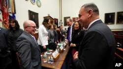 Rep. Gil Cisneros, D-Calif., right, talks to Navy Lt. Cmdr. Blake Dremann, left, and other transgender military members at the conclusion of a House Armed Services subcommittee hearing in Washington, Feb. 27, 2019.