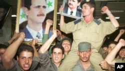 Syrian army soldiers waved portraits of Bashar al-Assad in Damascus in July, 2000, when he became president. 