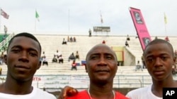 Larry Sawyer and Samba Koroma pose with their coach before a match
against Nigeria's youth team at Freetown's national stadium, 09 Dec 2009