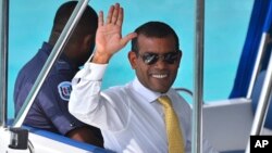 File - Maldives former President Mohamed Nasheed waves from a boat as he is taken back to Dhoonidhoo prison after a court dismissed his appeal against his arrest in Male, Maldives, March 2015.