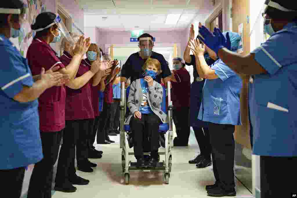 Margaret Keenan, 90, is cheered by workers after becoming the first patient in Britain to receive the Pfizer-BioNTech COVID-19 vaccine, at University Hospital, Coventry, England.
