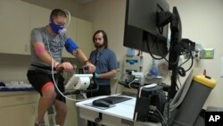 In this Nov. 18, 2019 image from video, Zach Ault of Paducah, Ky., is connected to medical monitors during an exercise test at the National Institutes of Health's hospital in Bethesda, Md. Ault has ME/CFS, what once was called "chronic fatigue syndrome." 