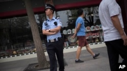 A police officer stands guard on the sidewalk of a street adjacent to Tiananmen Square in Beijing, June 4, 2016. The day marked the 27th anniversary of China’s bloody crackdown on pro-democracy protests which centered on the square.