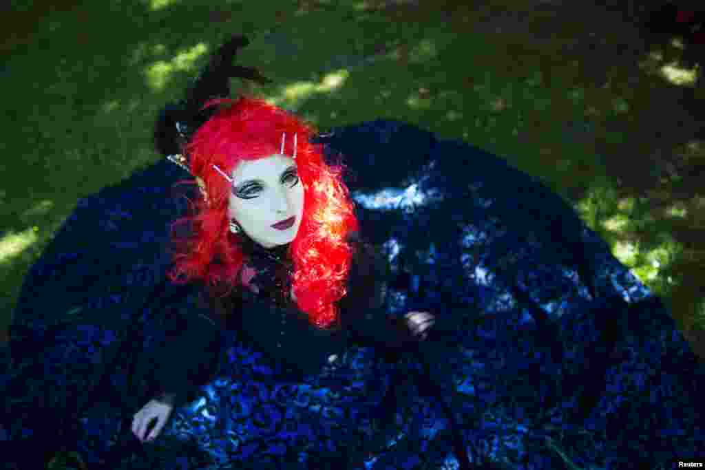 A reveler poses for pictures at the Victorian Picnic during the Wave and Goth festival in Leipzig, Germany. The annual festival, known in Germany as Wave-Gotik Treffen (WGT), features over 150 bands and artist in venues all over the city playing Gothic rock and other styles of the dark wave music subculture.