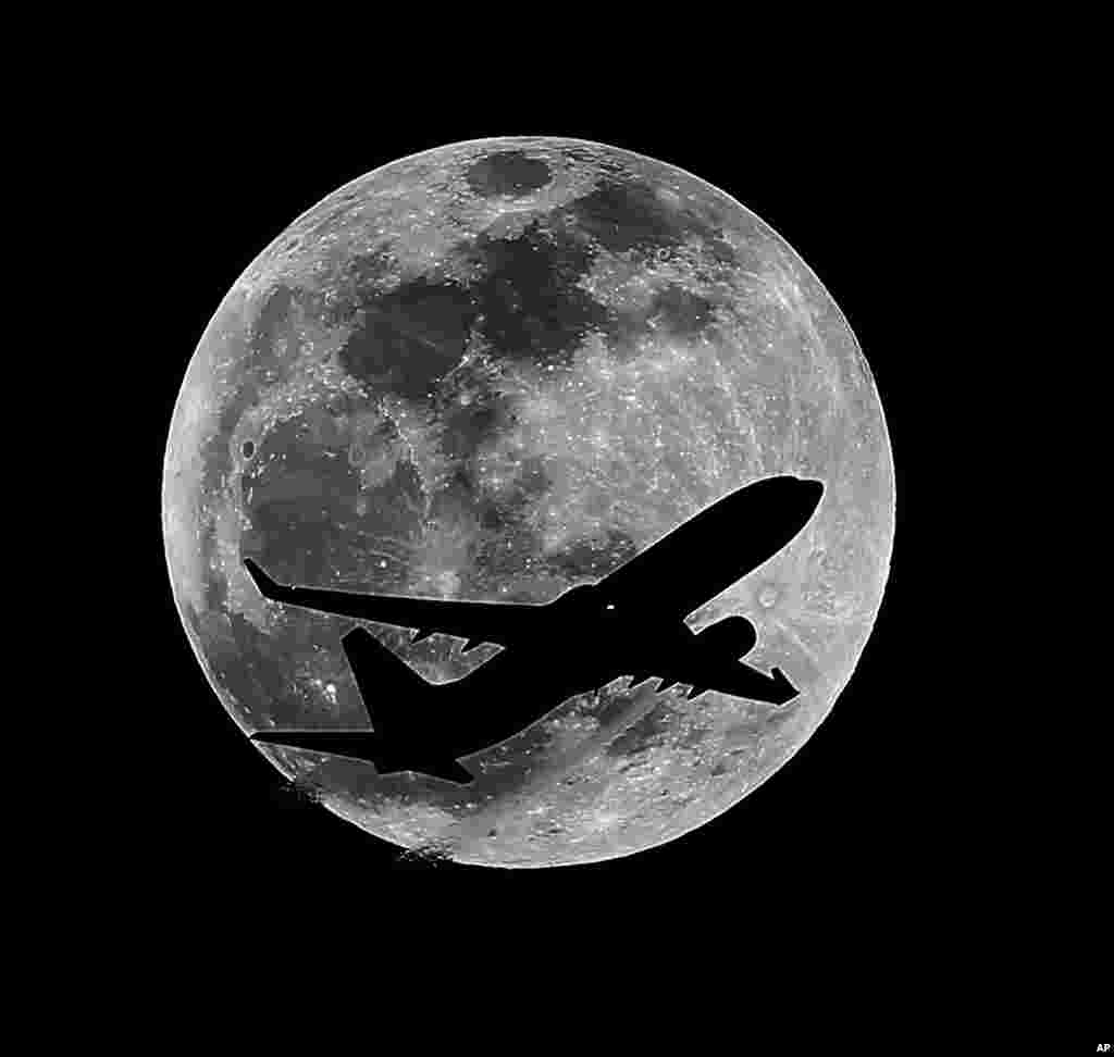 An airliner crosses the moon's path above Whittier, Calif., approximately one hour before a total lunar eclipse, April 14, 2014.