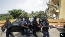 South African police officers stand guard around a car transporting President Jacob Zuma, as he leaves following a meeting with Ivory Coast's internationally-recognized president, Alassane Ouattara, at the Golf Hotel in Abidjan, Ivory Coast, February 22, 