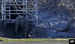 FILE - A pipe from the Dan River Power Plant where coal ash spilled is seen along the Dan River in Eden, N.C., Feb. 5, 2014.