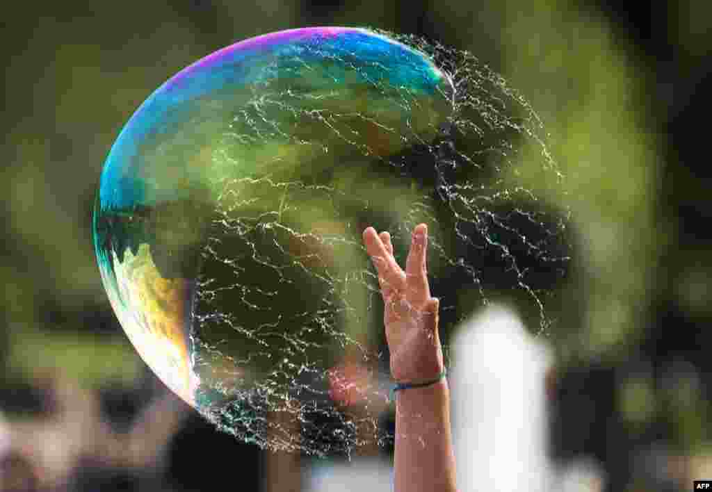 A boy bursts a soap-bubble at Gorky Park in Moscow, Russia.