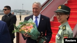 U.S. Defense Secretary Jim Mattis receives a bouquet upon arrival at an airport in Beijing, China June 26, 2018.