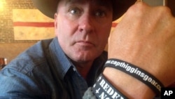 FILE - In this June 2, 2016, photo, Clay Higgins, then a candidate for Congress, poses for a photograph in Lafayette, La. His wristband is printed with the word "redemption." The Republican dubbed the “Cajun John Wayne” set his sights on and won a congressional seat.