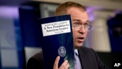 FILE - Budget Director Mick Mulvaney holds up a copy of President Donald Trump's proposed fiscal 2018 federal budget as he speaks to members of the media in the Press Briefing Room of the White House in Washington, May 23, 2019. 