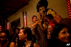 FILE - People dance along to a performance by band Wato in a bar in Saint-Louis, Senegal.