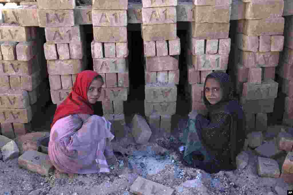 Children look through what is left from ashes of coal at a brick factory in Kabul, Afghanistan.