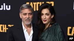 George Clooney y su 'defensora' Amal Clooney en la premiere de "Catch-22" en el Teatro Chino. Los Angeles, California, 7/5/19. Jordan Strauss/Invision/AP.