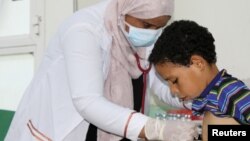 FILE - Nahla Arishi, a pediatrician, checks a boy infected with diphtheria at the al-Sadaqa teaching hospital in the southern port city of Aden, Yemen, Dec. 18, 2017. 