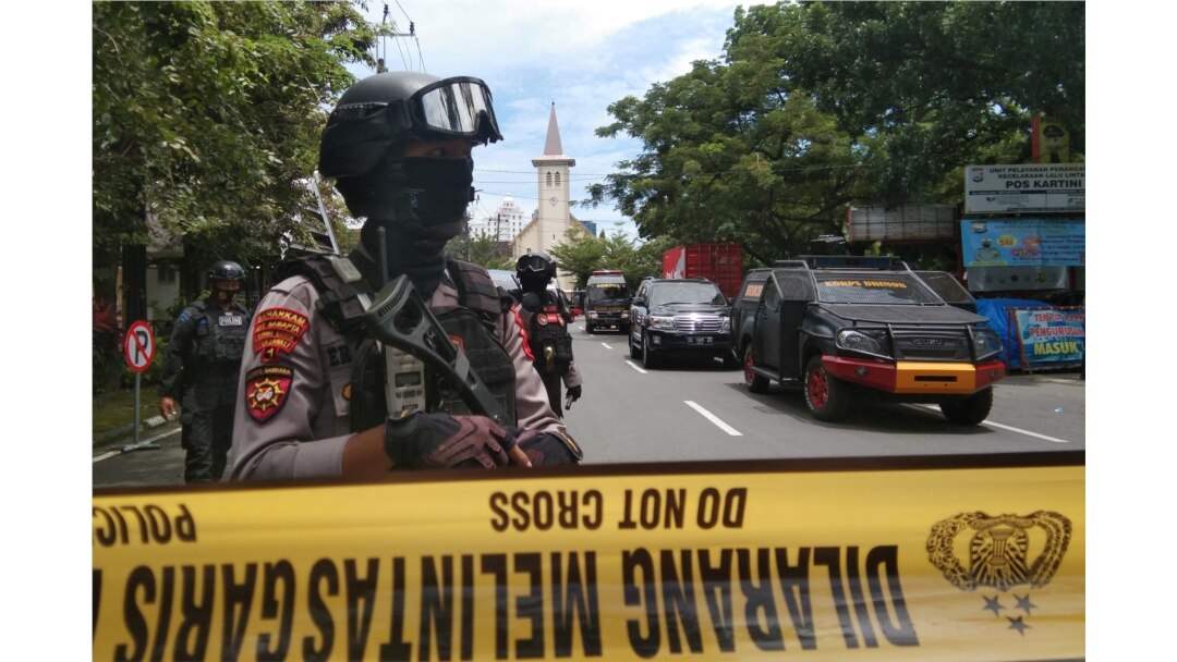 Petugas polisi bersenjata berjaga-jaga di sepanjang jalan tertutup menyusul ledakan di luar sebuah gereja Katolik di Makassar, Sulawesi Selatan, 28 Maret 2021. (Foto: Antara/Arnas Padda via REUTERS)