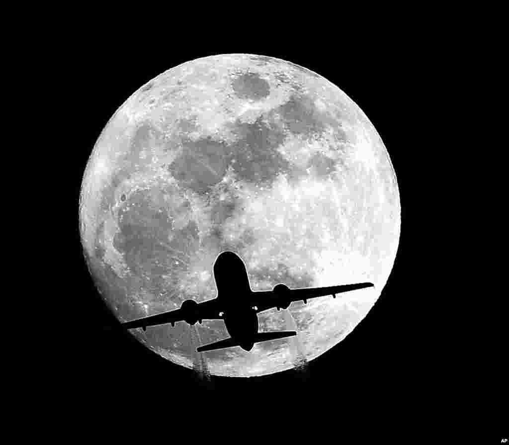 Sebuah siluet pesawat menuju Bandara Internasional Los Angeles defat Whittier, California, 24 Desember 2015, dengan latar belakang bulan yang hampir purnama. Bulan purnama ini dikenal sebagai &#39;Long Night Moon&#39; karena yang pertama setelah winter solstice atau hari terpendek dalam satu tahun, dan juga dikenal sebagai &#39;Cold Moon.&#39;