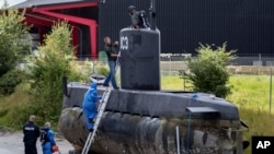 FILE - Police technicians board the amateur-built submarine UC3 Nautilus on a pier in Copenhagen harbour, Denmark, Aug. 13, 2017, to conduct forensic probes in connection with a murder investigation. 