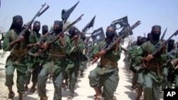 FILE - Al-Shabab fighters march with their weapons during military exercises on the outskirts of Mogadishu, Somalia, Feb. 17, 2011. 