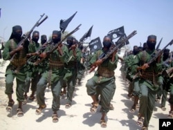 FILE - Al-Shabab fighters march with their weapons during military exercises on the outskirts of Mogadishu, Somalia, Feb. 17, 2011.