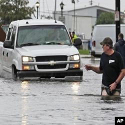 A man guides a truck through the flood waters caused by Tropical Storm Lee in New Orleans, Saturday, Sept. 3, 2011.