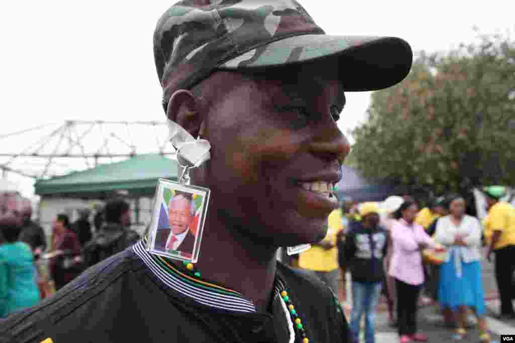 Thabo Tobedi usa brincos feitos a partir de porta-chaves para homenagear o seu herói Madiba, que para ele foi o responsável pelo bem-estar social (desde o vestir ao comer) de muitos dos negros sul-africanos. (Hannah McNeish VOA)