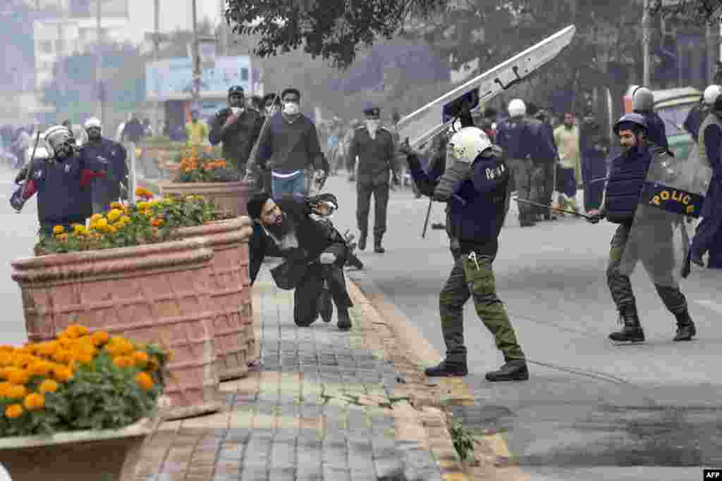 A policeman beats a lawyer during a clash between lawyers and doctors in Lahore, Pakistan. At least three heart patients died after a group of lawyers attacked doctors at a cardiac hospital in Lahore, officials and ministers said.