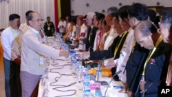 Myanmar President Thein Sein, front left, greets representatives of political parties during a meeting at Yangon region government office, Nov. 15, 2015. 