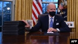 Predsjednik SAD Joe Biden poptisuje uredbe u Beloj kući, 21. januar 2020. (Foto:Jim WATSON / AFP)